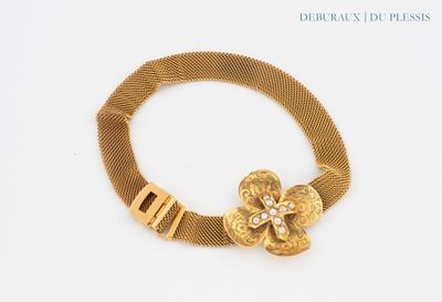 gold bracelet with a flower on a mesh bracelet with a clasp