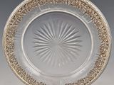 une assiette en verre ancienne ornée d'un motif circulaire sur le bord