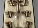 une bouteille en verre et six tasses dans une boîte