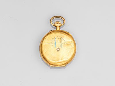 gros plan d'une montre de poche en or sur une surface blanche