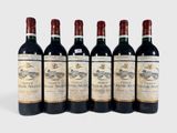 six bottles of wine are lined up in a row on a white surface