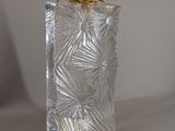 a silver glass bottle with a black top on a table