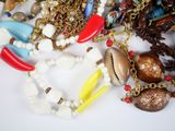 a lot of necklaces and bracelets on a white surface