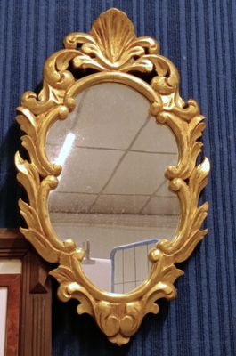 a mirror hanging on the wall next to a framed picture