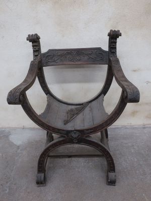 a wooden chair that is sitting in front of a wall