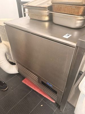 un plan de travail en acier inoxydable sur lequel sont posées des casseroles et des poêles