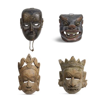quatre masques en bois représentant différents visages sur fond blanc