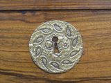a keyhole in the middle of a wooden drawer