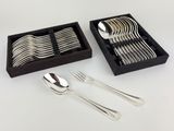 a set of silverware in a black box on a white table