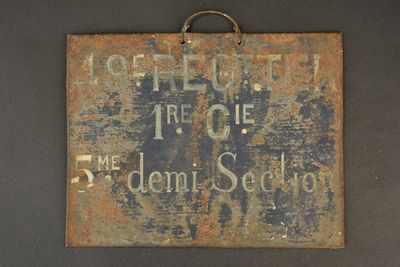 an old sign hanging on the wall of a building