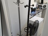 an image of a room with a fan and clothes rack