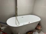 a white bathtub in a bathroom with a shower head on the wall
