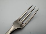 a close up of a fork on a table with a white background
