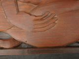 a wooden carving of a bird on a shelf
