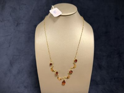 a close up of a necklace on a mannequin with a price tag