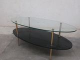 a glass table with gold legs and a glass top