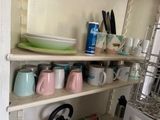 many cups and plates on the shelves in the kitchen