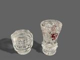 two glass vases sitting next to each other on a table
