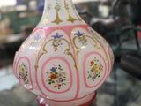 un vase rose et blanc posé sur une table en verre
