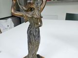 a statue of a woman holding a bowl on her head