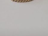 a close up of a gold ring on a white surface