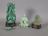 trois figurines assises l'une à côté de l'autre