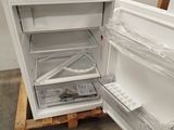 a white refrigerator with its door open on a pallet