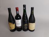 quatre bouteilles de vin sont alignées sur une table