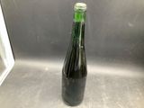 a bottle of beer sitting on a metal counter