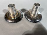 two metal candlesticks that are on a table
