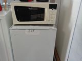 a microwave sitting on top of a refrigerator in a kitchen