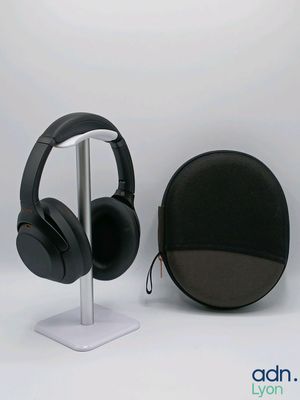 a pair of headphones sitting on a stand next to a bag