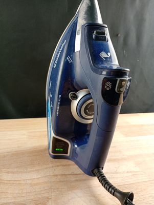un fer à repasser bleu posé sur une table en bois