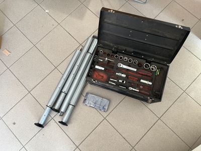 une trousse à outils posée par terre à côté des toilettes