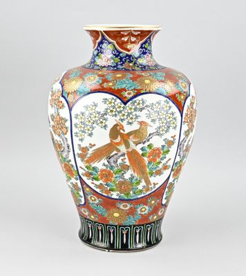 un vase avec un oiseau posé sur une table