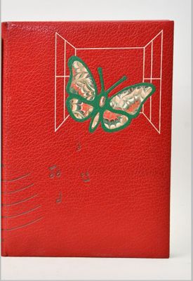 a close up of a red book with a butterfly on it