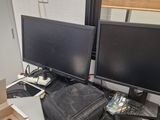 two computer monitors sitting on top of a desk next to a laptop
