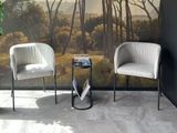 two chairs in front of a wall with a painting on it