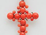 a close up of a cross made out of coral beads