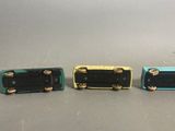 three different colors of radio sitting on a table