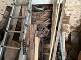 a ladder that is leaning against a wall next to a pile of wood