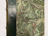 un vieux livre à la couverture noire ornée d'un motif marbré