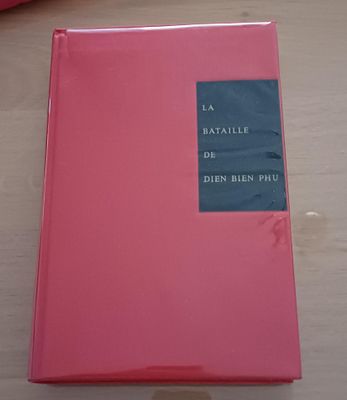 un livre rose posé sur une table en bois
