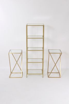 un ensemble de trois tables d'appoint en métal doré et en verre