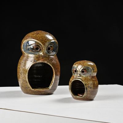 deux figurines de chouettes en céramique posées sur une table blanche