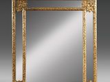 un miroir orné d'un cadre doré sur fond gris
