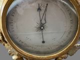 a gold clock on a stand with a clock face on it