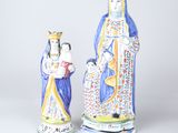 deux figurines en céramique représentant une femme et un homme avec un enfant