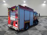 a red fire truck parked in a room with a checkered floor