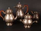 three pieces of silver tea and coffee set on a black background